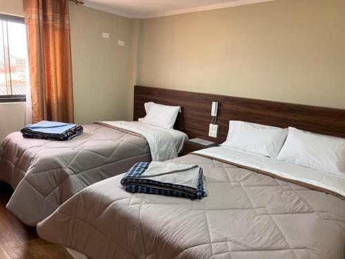 Dos camas en una habitación de hotel con toallas. en Ayña Hotel, en Chachapoyas