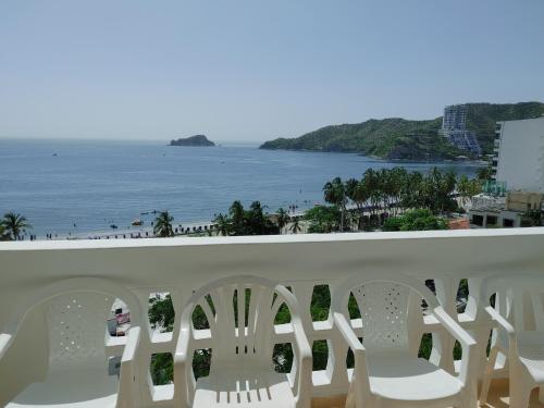 a balcony with white chairs and a view of the beach at Apartamento en el Rodadero con vista al mar, edificio Macondo in Rodadero