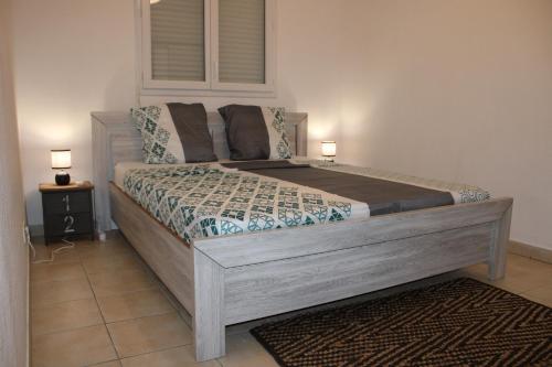 - un grand lit dans une chambre avec 2 lampes sur une table dans l'établissement L'hibiscus - Proche centre de Cayenne, à Cayenne
