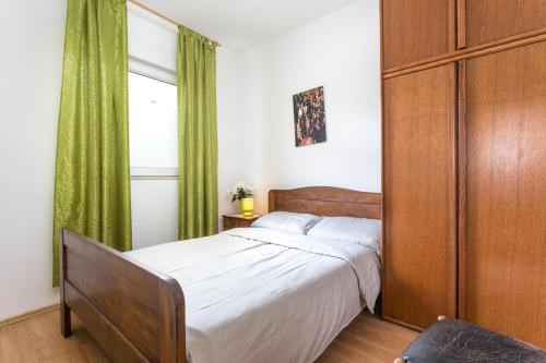 1 dormitorio con 1 cama y cortina verde en Apartments with a parking space Kastel Stafilic, Kastela - 20926, en Kaštela