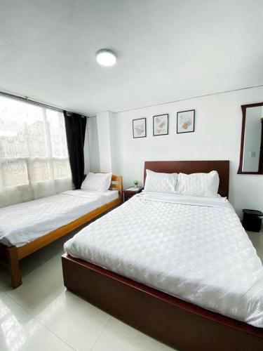 波哥大的住宿－Royal Rooms，一间卧室设有两张床和窗户。