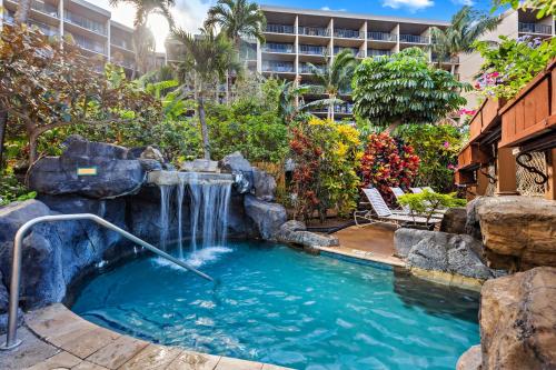 a swimming pool with a waterfall in a resort at Kaanapali Shores 640 in Kahana