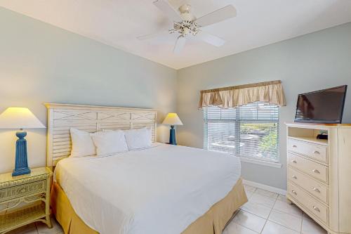um quarto com uma cama, uma ventoinha de tecto e uma televisão em Waterfront Haven Retreat em Destin