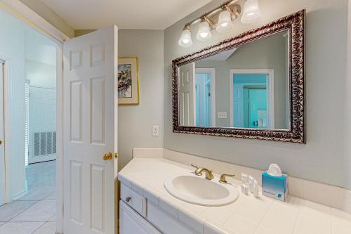 uma casa de banho com um lavatório e um espelho em Waterfront Haven Retreat em Destin