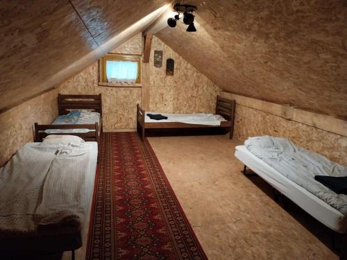 a attic room with two beds and a window at Cowboy House at Ranch Lambergar 