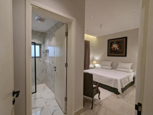a bedroom with a bed and a walk in shower at Ain Arees in Al Madinah