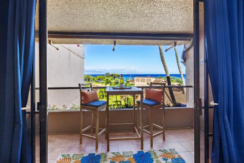 Kahana Villa F407 في Kapalua-West Maui Airport: شرفة مع طاولة وكراسي وإطلالة على المحيط
