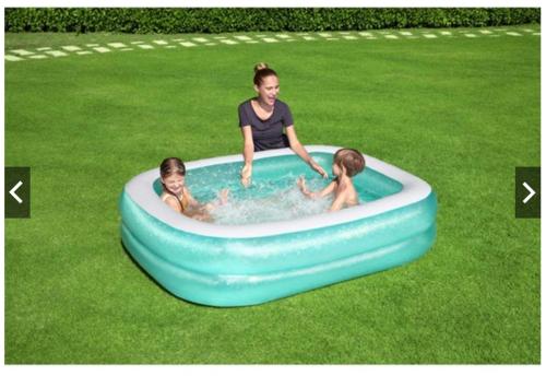 a woman and two children in a swimming pool at RAPID Pelali Pengerang Homestay in Pengerang