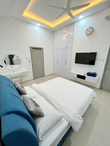 a bedroom with a large bed and a flat screen tv at RAPID Pelali Pengerang Homestay in Pengerang