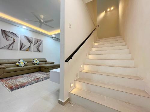 a staircase in a living room with a couch at RAPID Pelali Pengerang Homestay in Pengerang