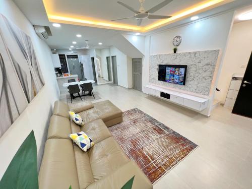ein Wohnzimmer mit einem Sofa und einem TV in der Unterkunft RAPID Pelali Pengerang Homestay in Pengerang