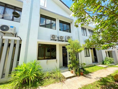 a white building with windows and plants at RAPID Pelali Pengerang Homestay in Pengerang