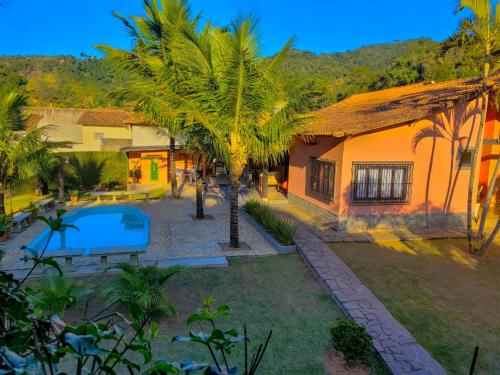 an aerial view of a house with a pool and palm trees at Villa Terracotta in Miguel Pereira
