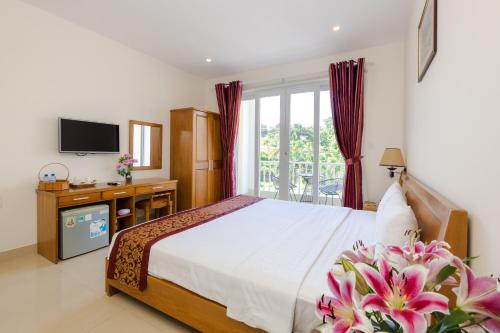 1 dormitorio con 1 cama grande y TV en T&T Resort And Spa, en Phu Quoc