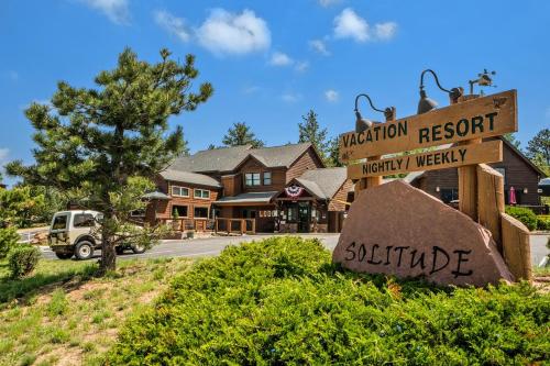 um sinal em frente a um resort de montanha e a uma casa em Solitude Marmot #1 - Estes Park condo em Estes Park