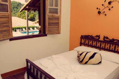 a bedroom with a bed and a window with a view at Hotel Fazenda Coninho in Inhaúma