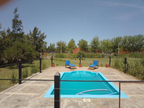 einen Pool mit zwei blauen Stühlen im Hof in der Unterkunft La posada de Don Santiago in Villa Lía