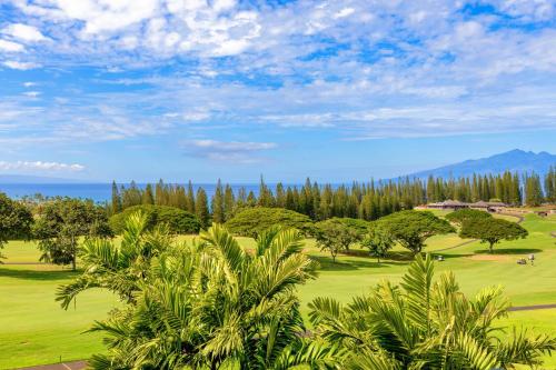 Blick auf einen Golfplatz mit Palmen und das Meer in der Unterkunft Kapalua Golf Villa 18V4 in Kahana
