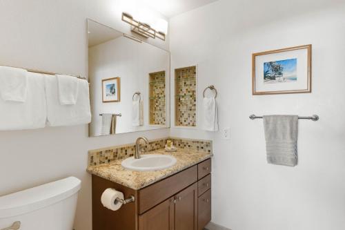 a bathroom with a sink and a toilet and a mirror at Kapalua Golf Villa 18V4 in Kahana
