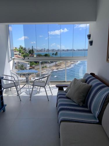 sala de estar con sofá y vistas al océano en Apartamento vista do mar, pé na areia e águas tranquilas, no cento de Guarapari, en Guarapari