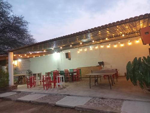 rodante el piñon en EZEQUIEL MONTES في ازيكويل مونتيس: فناء مع طاولة وكراسي وأضواء