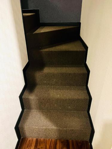 a black staircase with wooden floors in a room at ホテル CROWN MOTEL in Yokohama