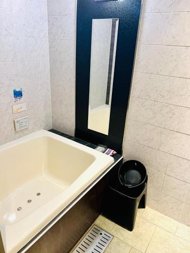 a bathroom with a bath tub and a trash can at ホテル CROWN MOTEL in Yokohama