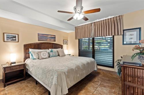 um quarto com uma cama e uma ventoinha de tecto em Noelani 208 em Kahana