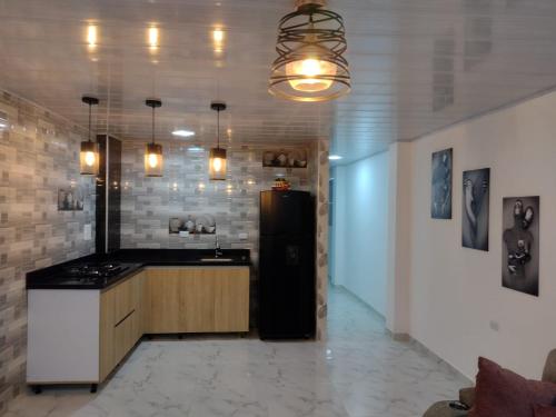 cocina con nevera negra en una habitación en Apartahotel Los Ángeles en Cartagena de Indias