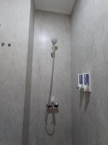 a shower stall with a shower head in a bathroom at Grownicle Living Syariah in Timuran