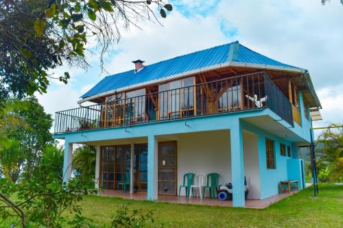 a house with a blue roof and a balcony at HOTEL PANORAMA SOL in Chachagüí