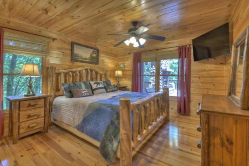 a log cabin bedroom with a bed and a ceiling fan at Bella Vista in Ellijay