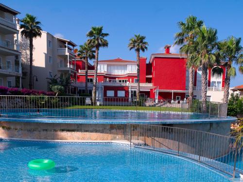 a swimming pool with a green frisbee in front of buildings at HG Jardín de Menorca in Son Bou