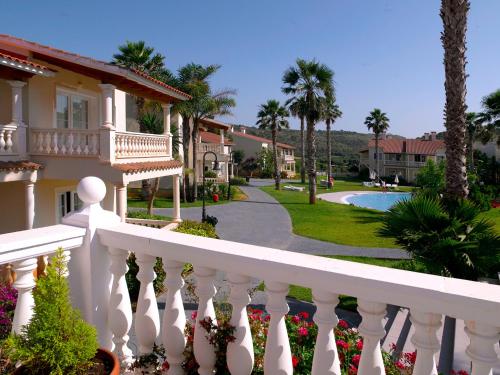 蘇昂博的住宿－HG Jardín de Menorca，房屋前的白色围栏,带游泳池