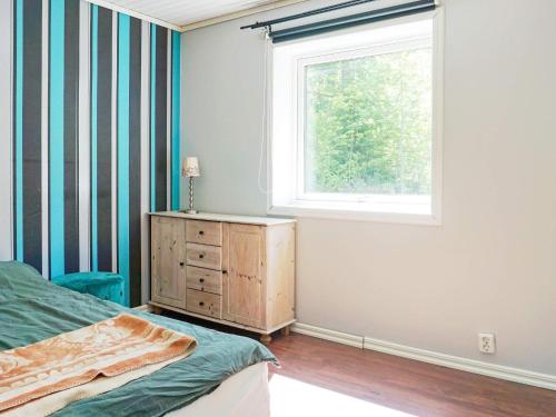 1 dormitorio con cama, ventana y vestidor en Holiday home Hållnäs, en Hållnäs