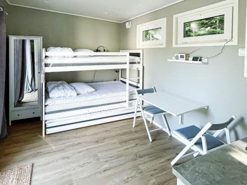 Zimmer mit 2 Etagenbetten, einem Tisch und einem Schreibtisch in der Unterkunft Holiday home LJUNGBY IV in Ljungby