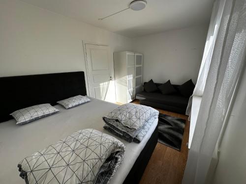 a bedroom with a large bed and a couch at luxurious 2-room apartment in central Borås in Borås