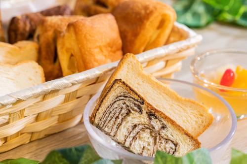 a basket of bread and a piece of toast at Kuretake Inn Premium Nagoya Nayabashi in Nagoya