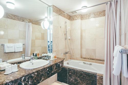 沼津的住宿－沼津河畔酒店，一间带水槽、浴缸和淋浴的浴室