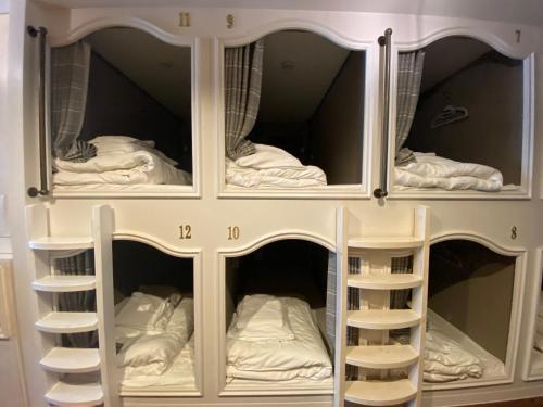 białe łóżko piętrowe z półkami w pokoju w obiekcie ステイワーク錦糸町 w Tokio