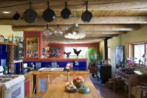 eine Küche mit einem Tisch, Töpfen und Pfannen in der Unterkunft Casa Gallina - An Artisan Inn in Taos