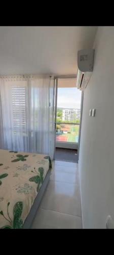 a bedroom with a bed and a large window at Apartamento en Condomio Peñazul La Aldea en Ricaurte - Girardot in Ricaurte