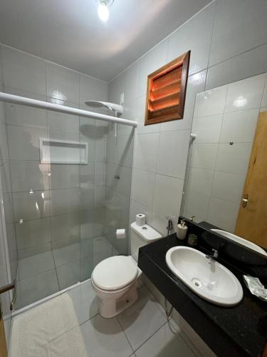 a white bathroom with a toilet and a sink at Villa Dom Felippe in Jericoacoara