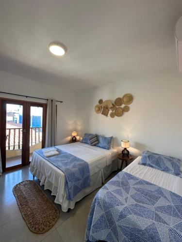 a bedroom with two beds and a balcony at Villa Dom Felippe in Jericoacoara