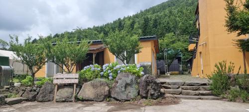 a building with a bench and some rocks and trees at Jeju Best Hill in Jeju