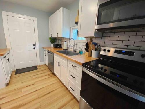 a kitchen with white cabinets and a black stove top oven at Holy City Bungalow in Charleston