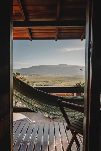 a hammock on a balcony with a view of the desert at Pousada Colina Verde in Garopaba