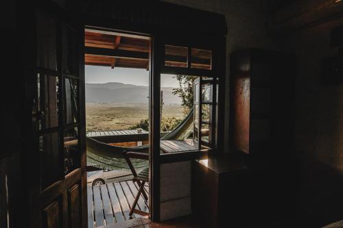 a room with a view of a hammock on a porch at Pousada Colina Verde in Garopaba