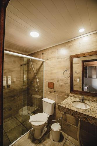 a bathroom with a toilet and a sink and a shower at Pousada Colina Verde in Garopaba