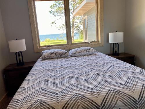 a bedroom with a large bed with a window at Bodin's Resort in Washburn